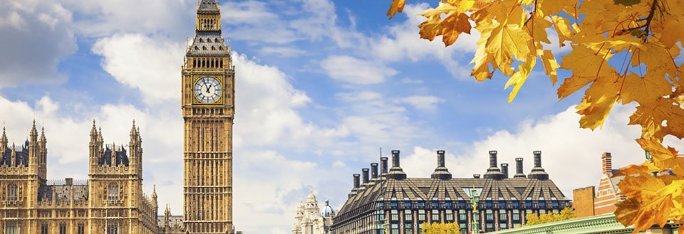 Det ikoniska Big Ben och Westminsterpalatset i London omgivet av gyllene höstlöv.