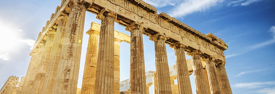 Bilden visar de ståtliga ruinerna av Parthenon på Akropolis i Aten, belysta av solskenet.