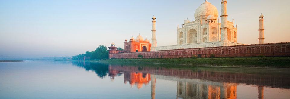 Taj Mahal vid floden Yamunas med en vacker spegling i vattnet vid gryningen.