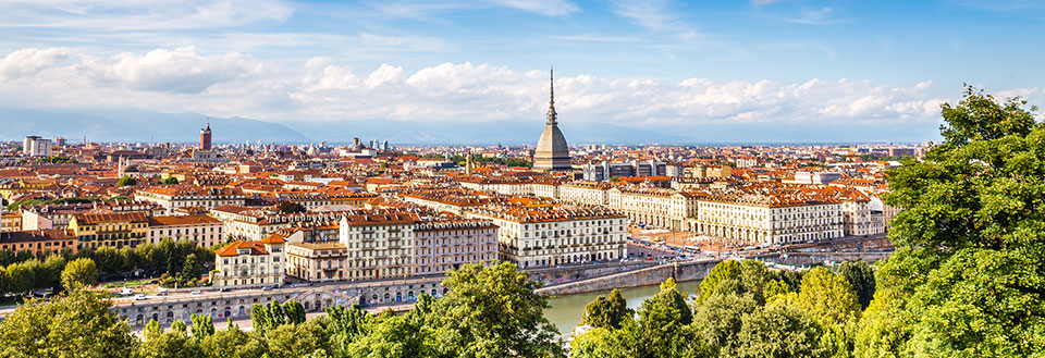 Panoramavy över  Torino med historiska byggnader och en flod som skär genom staden.