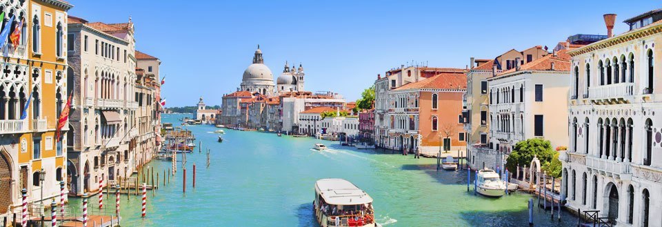 Den myllrande Canal Grande i Venedig med färgstarka byggnader och båtar.